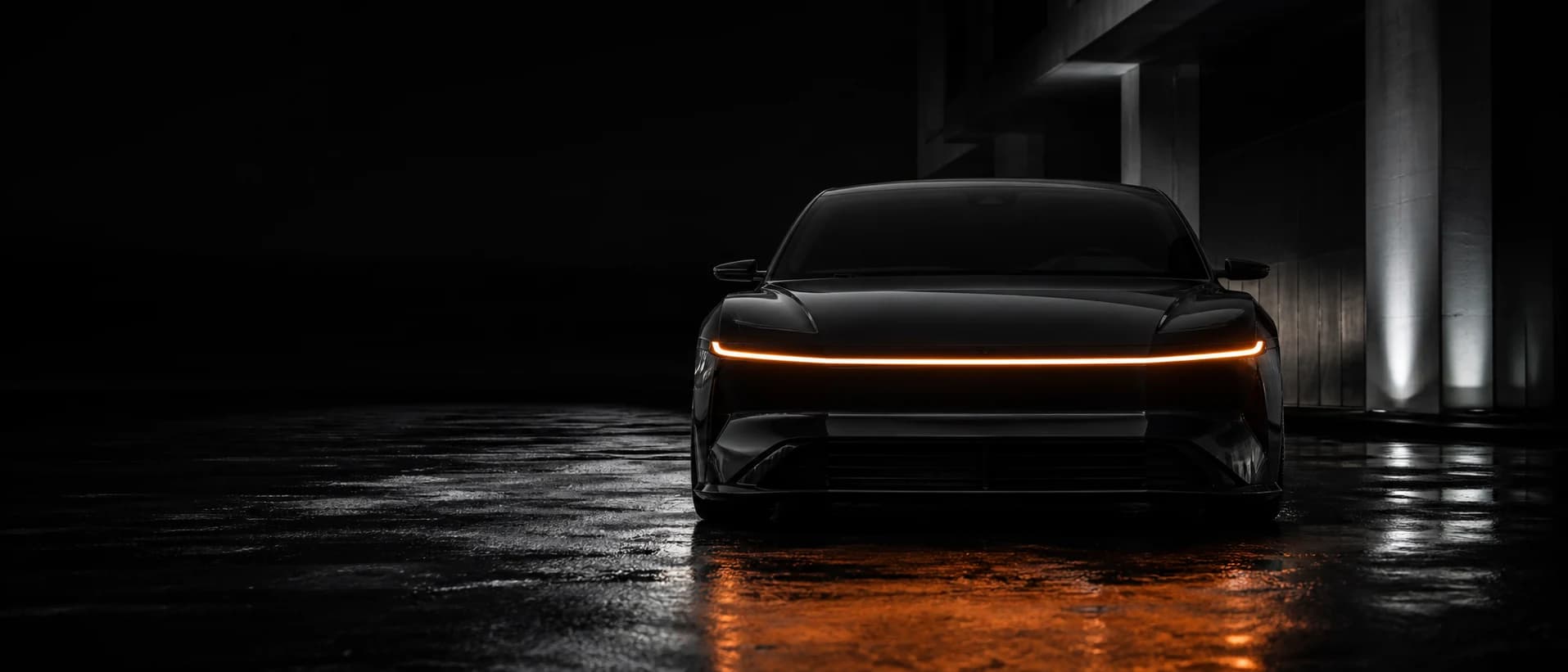 A Veltrix Arcen photographed head-on at night, its full-width light bar the only source of color in the frame