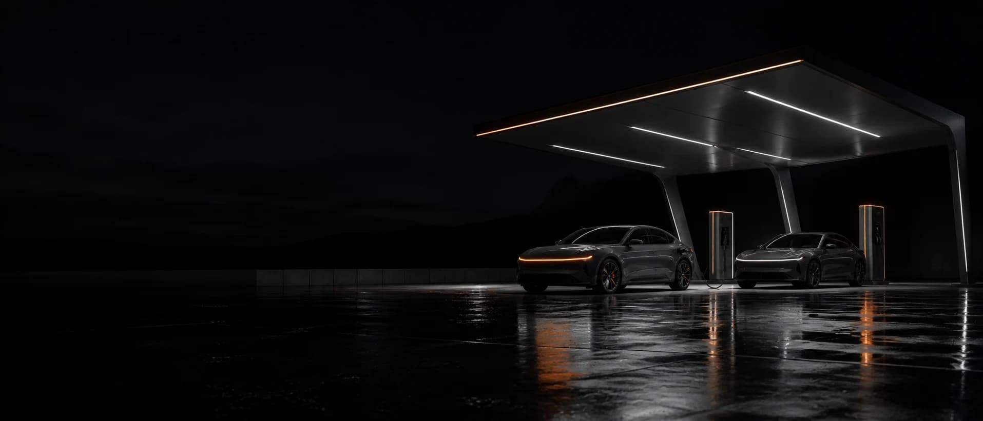 A Veltrix Current 350 charging site at night, canopy lights reflected on wet concrete