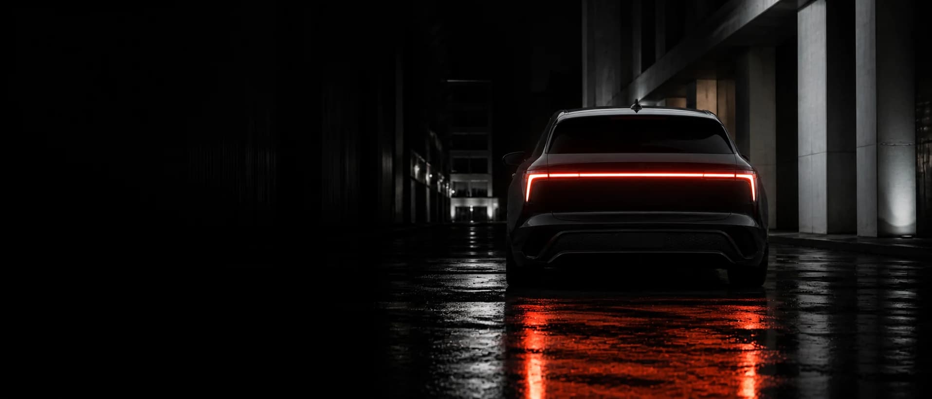 Rear view of the Veltrix Nyra at night, its full-width light bar reflected on wet asphalt